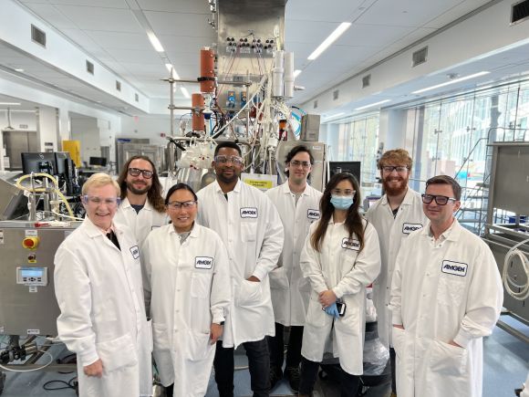 A group of people in lab coats standing in a laboratory