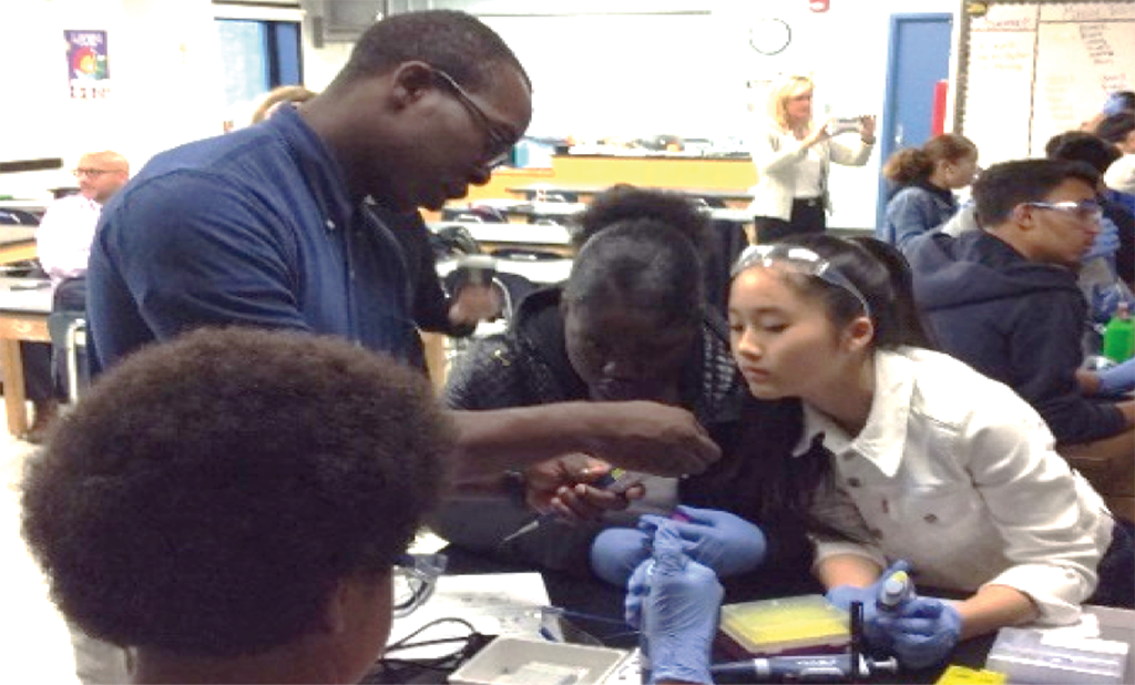 Teacher showing something to students in a lab.