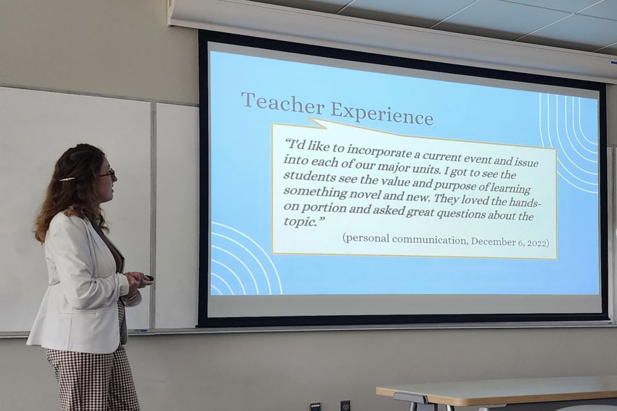 Teacher at front of classroom showing slide