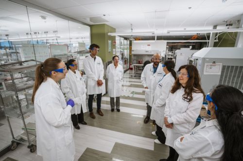 mtf teachers and Amgen scientists standing in lab coats at Amgen Massachusetts