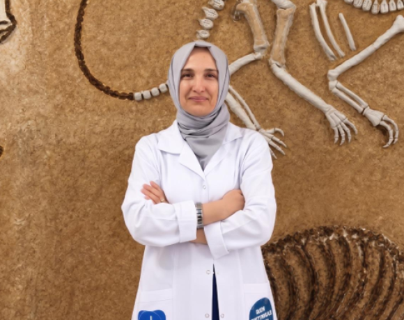 Woman in white lab coat facing the camera